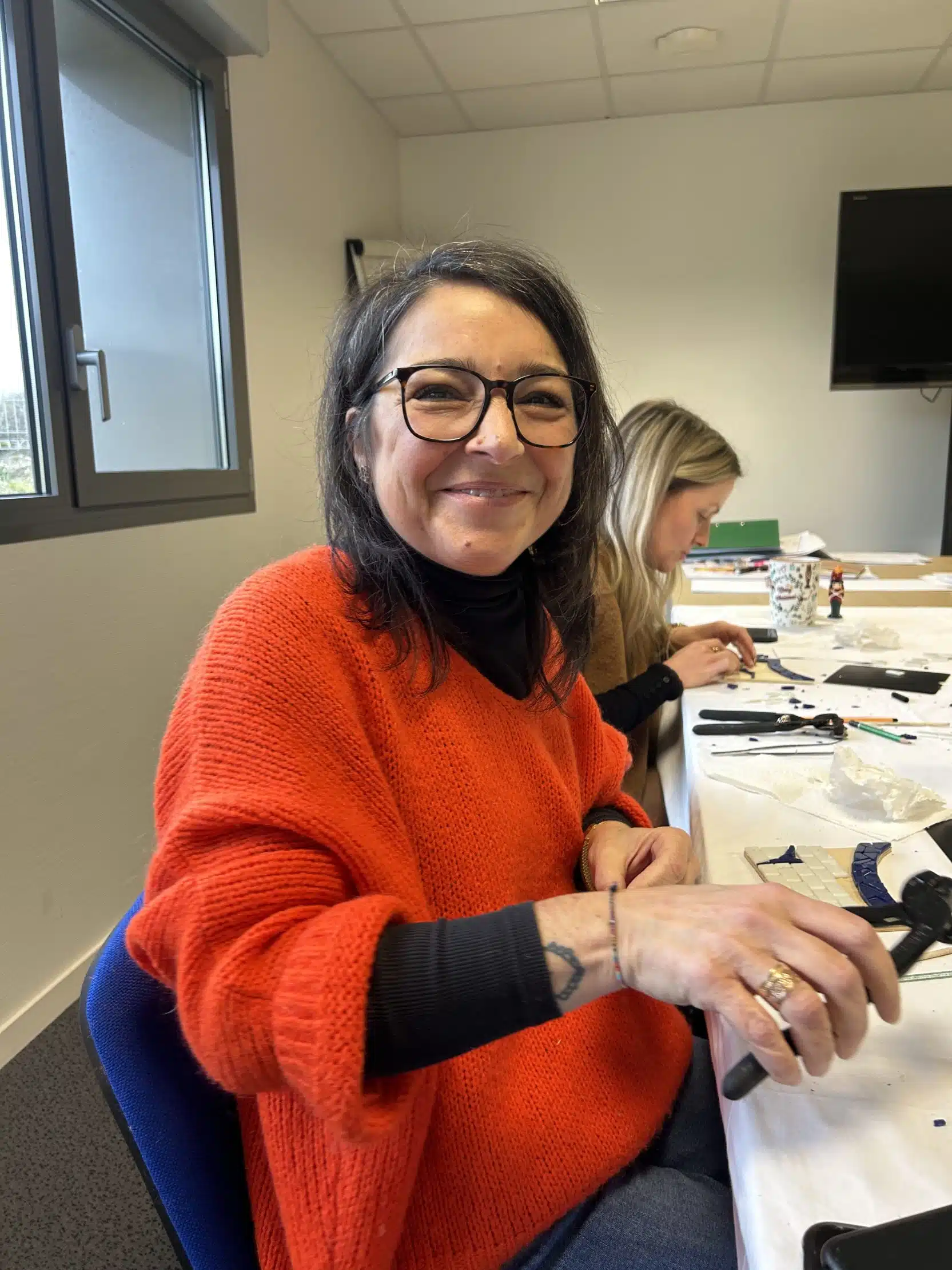 Femme en pull orange, atelier créatif.